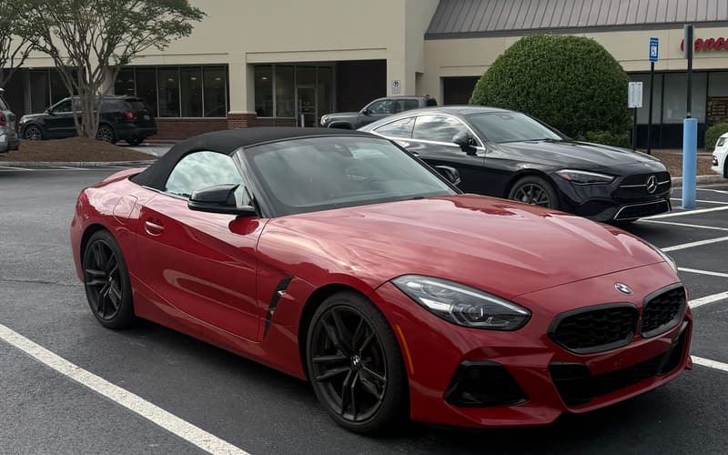 2024 BMW Z4 sDrive30i in San Francisco Red, front three-quarter view with the black soft top up